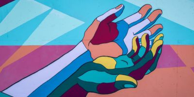 Artwork painting of colourful hands on a wall/ CC0 Tim Mossholder